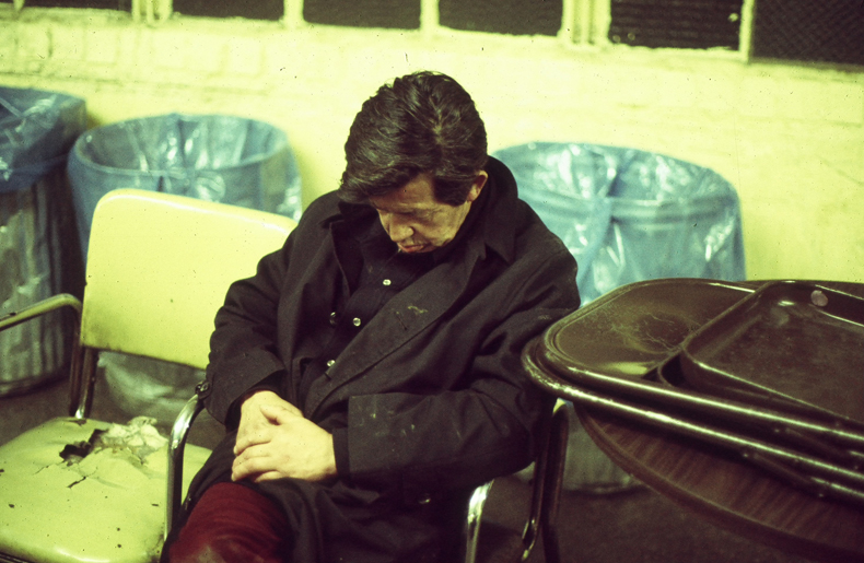 Photo of homeless man asleep on a chair